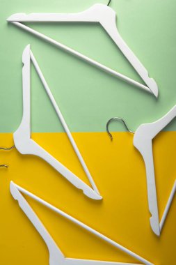 Beyaz askıları ve kancalar çok renkli backgraund üzerinde. Düz yatıyordu. Kavram görünümü.