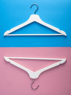 İki beyaz askı. Mavi ve pembe arka planda Woden askıları. Metin için alan kopyalayın. Düz yatıyordu