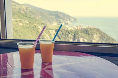 İki su bardağı taze sıkılmış portakal suyu deniz manzaralı.