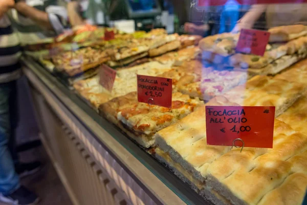 Lokalna piekarnia sprzedaży pyszne pizze i focaccia chleb. — Zdjęcie stockowe