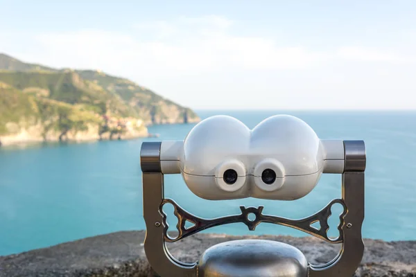 Jumelles touristiques à monnaie opéré en mer regardant une ville lointaine . — Photo
