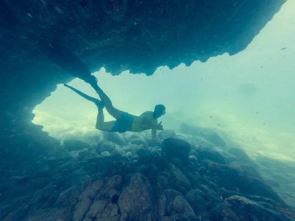 Nuoto subacqueo maschile attraverso tunnel subacquei naturali . — Foto Stock