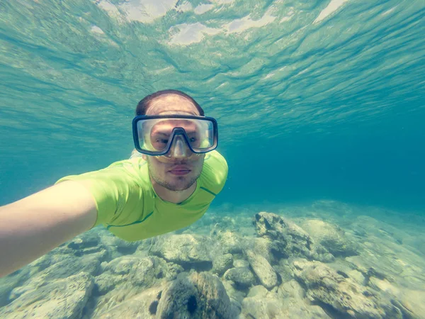 Plongeur mâle prenant un selfie pendant la plongée avec tuba . — Photo
