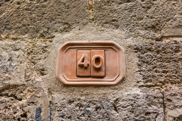 House number carved into clay tablet on facade.