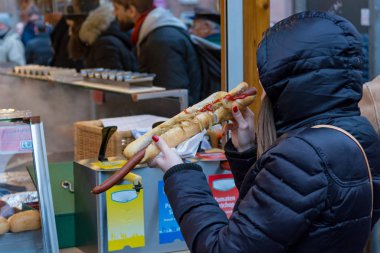 Aç kişi açık standında gülünç uzun sosisli sandviç yeme.