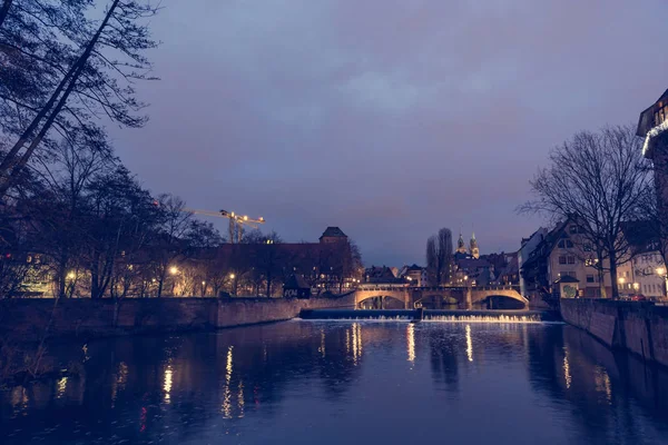 Vista notturna del ponte medievale che attraversa un fiume . — Foto Stock