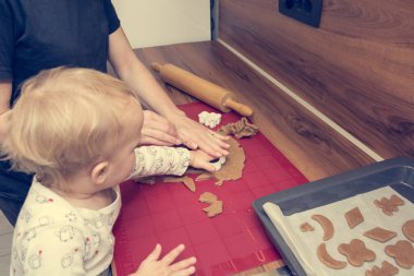 Annesi kızının kurabiye pişirmeye öğreterek.