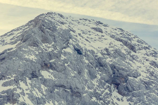 Rescue helicopter flying near mountain range to pick wounded. — Stock Photo, Image