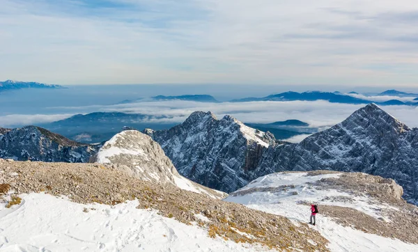 Alpinista femminile che scende nella valle di montagna attraversando fiocchi di neve . — Foto Stock