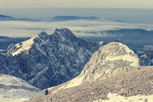 Alpinistin steigt ins Gebirgstal und überquert Schneeflocken. — Stockfoto