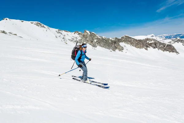 Feminino esquiador de fundo do país abordando uma encosta íngreme . — Fotografia de Stock