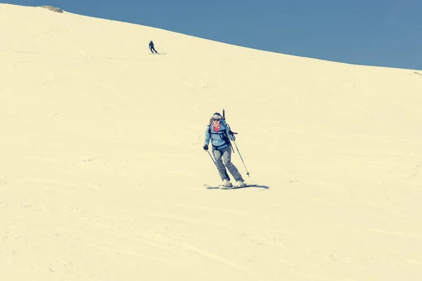 Feminino esquiador de fundo do país abordando uma encosta íngreme . — Fotografia de Stock