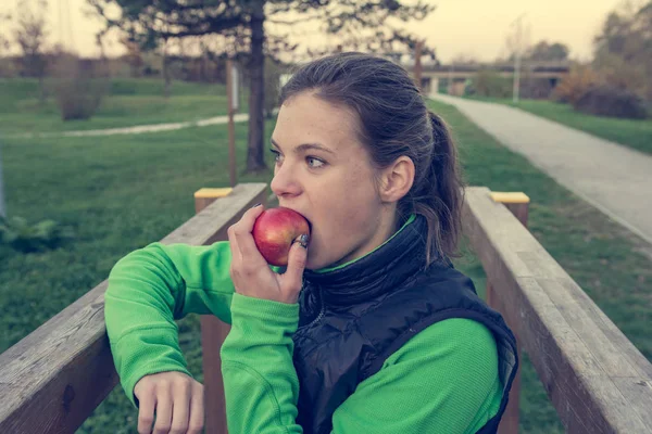 Mulher atlética tendo um lanche de frutas saudável durante o exercício ao ar livre . — Fotografia de Stock