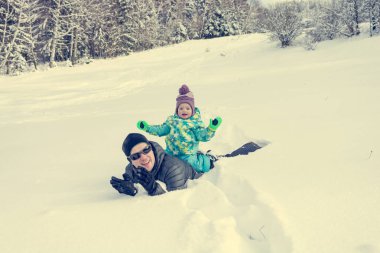 Baba ve kızı taze karda oynarken.