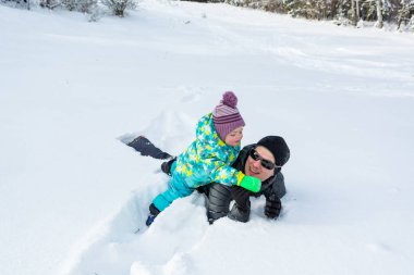 Baba ve kızı taze karda oynarken.