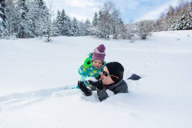 Baba ve kızı taze karda oynarken.