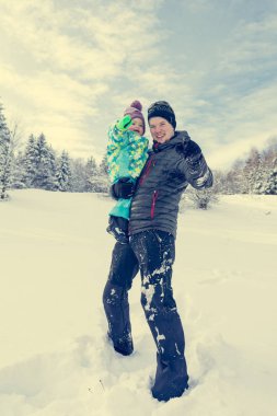 Baba ve kızı taze karda oynarken.
