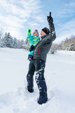 Baba ve kızı taze karda oynarken.