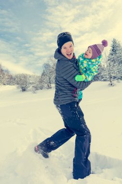 Baba ve kızı taze karda oynarken.