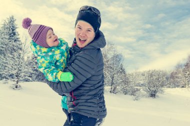 Baba ve kızı taze karda oynarken.