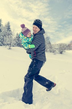 Baba ve kızı taze karda oynarken.