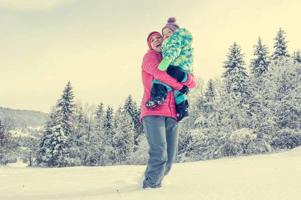 Mor och dotter spelar i sagan vinterlandskap. — Stockfoto