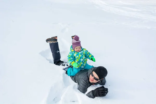 Vader en dochter spelen in de verse sneeuw. — Stockfoto