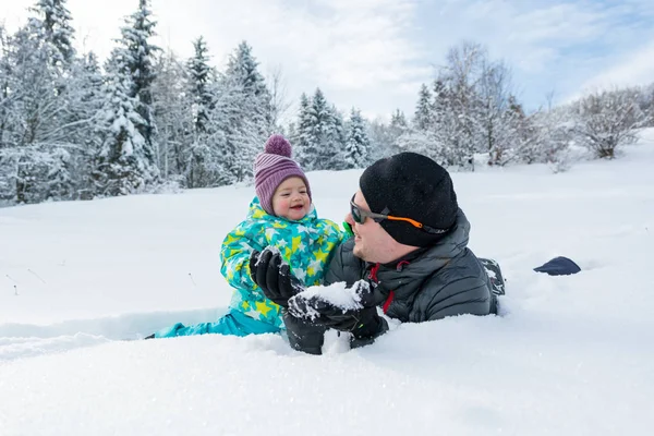 Otec a dcera hraje v čerstvém sněhu. — Stock fotografie