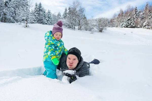 Vader en dochter spelen in de verse sneeuw. — Stockfoto