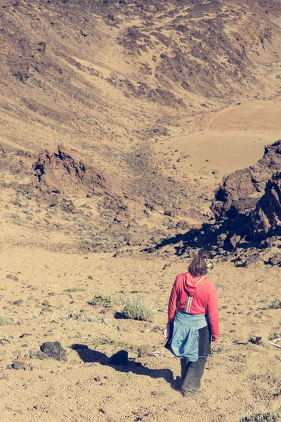 Sporty woman running down volcanic slope lifting dust trail. — Stock Photo, Image