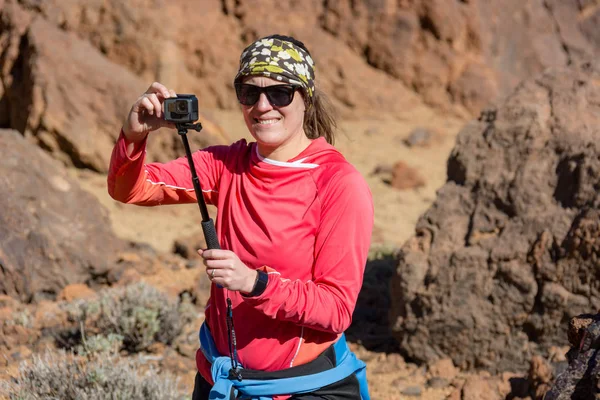 Aventura vloger femenino utilizando la cámara de acción al aire libre . — Foto de Stock