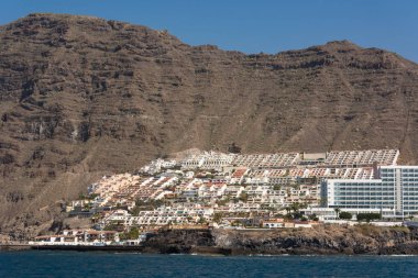 Okyanus bağlantı noktası şehrin altında dik kayalıklarla - tekne görünümünden.