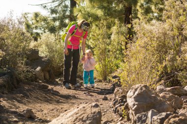 Anne ve kızı birlikte orman patika üzerinde yürüme.
