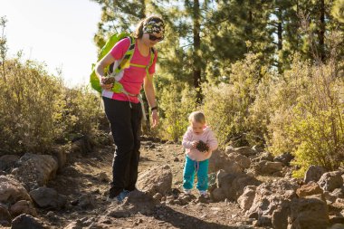 Anne ve kızı birlikte orman patika üzerinde yürüme.