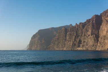 Denizin üzerinde yükselen dik dik kayalıklarla.