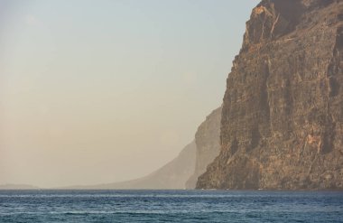 Denizin üzerinde yükselen dik dik kayalıklarla.