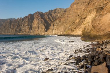 Denizin üzerinde yükselen dik dik kayalıklarla.