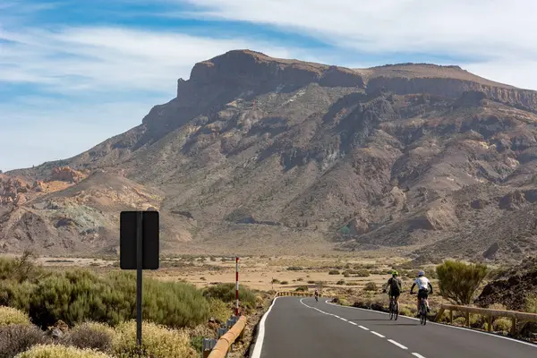 Ciclista en bicicleta en una carretera a través del paisaje volcánico . — Foto de Stock