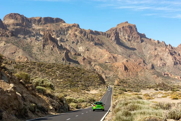 Auto fährt auf einer Straße durch spektakuläre Vulkanlandschaft. — Stockfoto