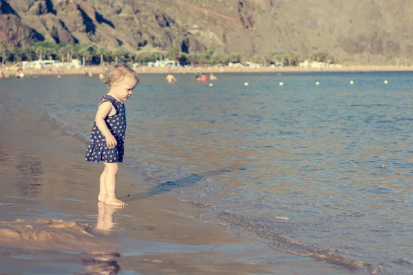 Menina bonito jogando na praia de areia e explorando . — Fotografia de Stock