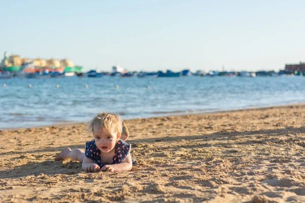 Menina bonito jogando na praia de areia e explorando . — Fotografia de Stock