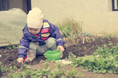 Küçük kız bahçe keşfetmek ve bahar temizliği ile yardımcı.