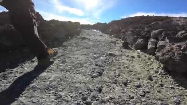 Low level footage of hiking a path across volcanic wasteland. — Stock Video