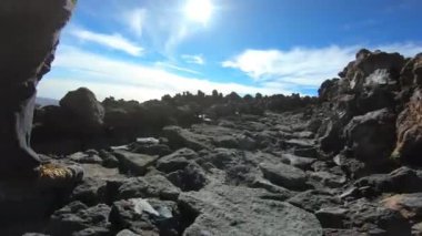 Volkanik çorak arazide bir yol yürüyüş düşük düzeyde görüntüleri.