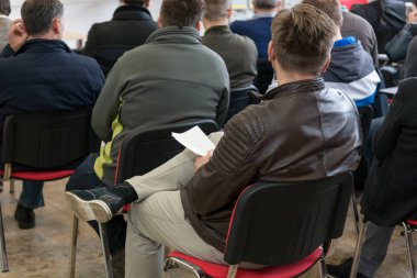 İş sunumunda dinleyiciler konuşma yapan kişiyi dinliyor.