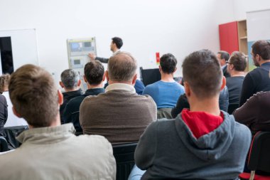 İş sunumunda dinleyiciler konuşma yapan kişiyi dinliyor.