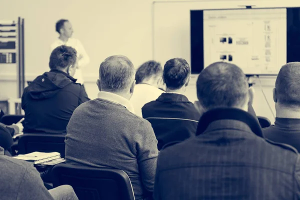Audiencia en la presentación de negocios escuchando a la persona que da un discurso . — Foto de Stock