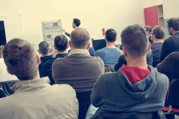 Audiencia en la presentación de negocios escuchando a la persona que da un discurso . — Foto de Stock