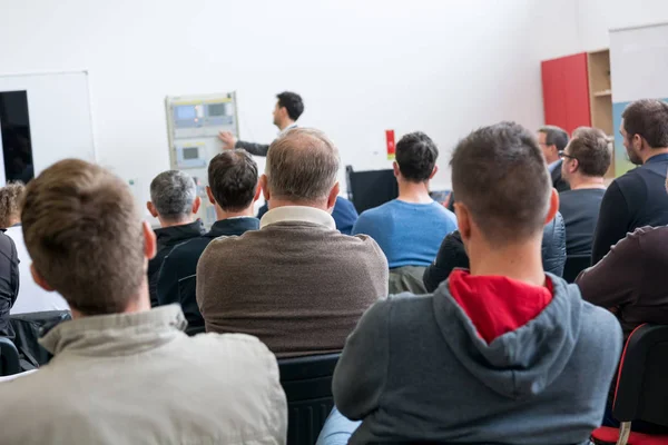 Audiencia en la presentación de negocios escuchando a la persona que da un discurso . — Foto de Stock