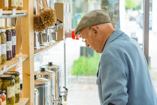 Älterer Mann schaut sich Produkte im örtlichen Bioladen an. — Stockfoto